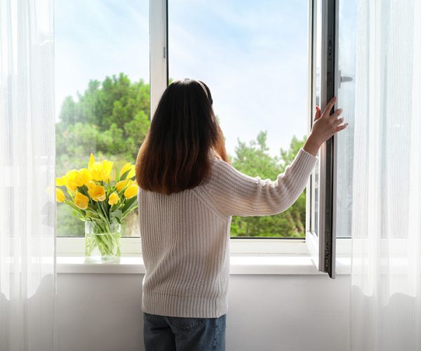 femme-ouverture-fenetre Une femme ouvre une fenêtre