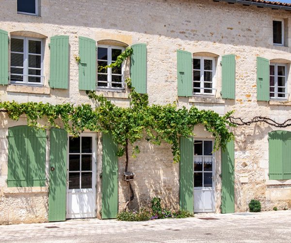 Grande maison avec des volets verts